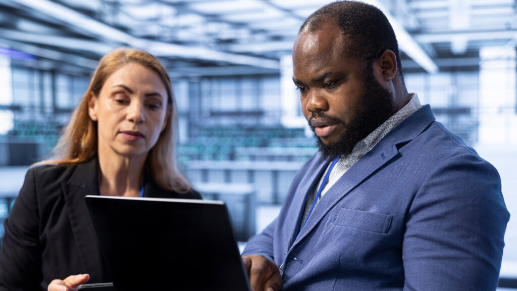 Infor Featured Image showing to Enterprise workers discussing information on laptop screen