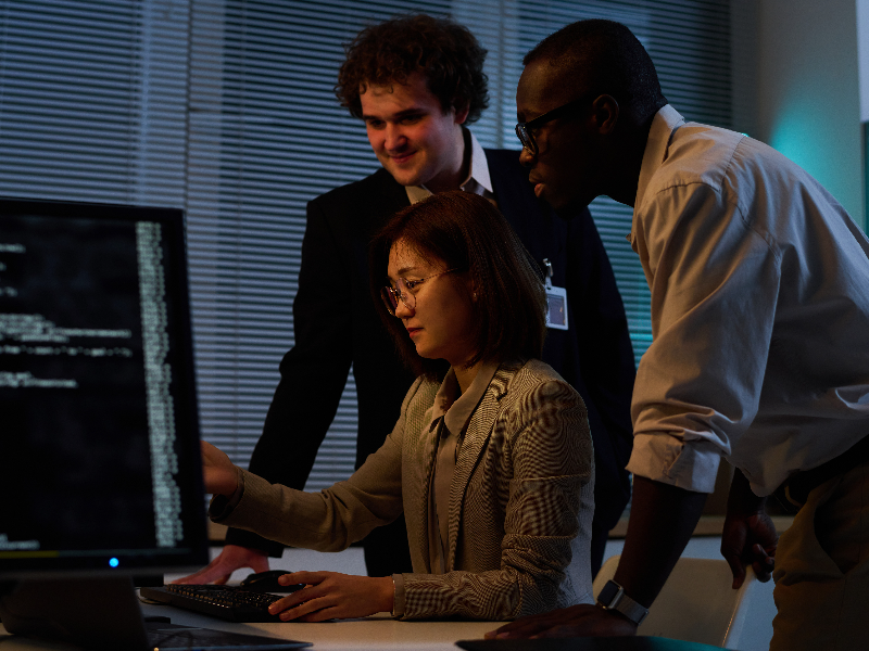 IT support staff huddling around a computer