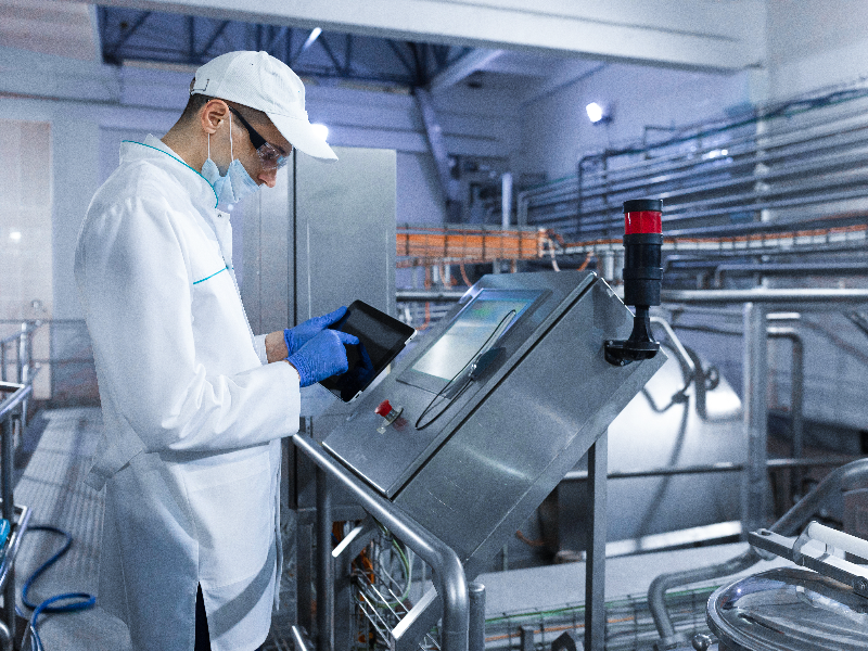 Factory worker on a tablet processing orders